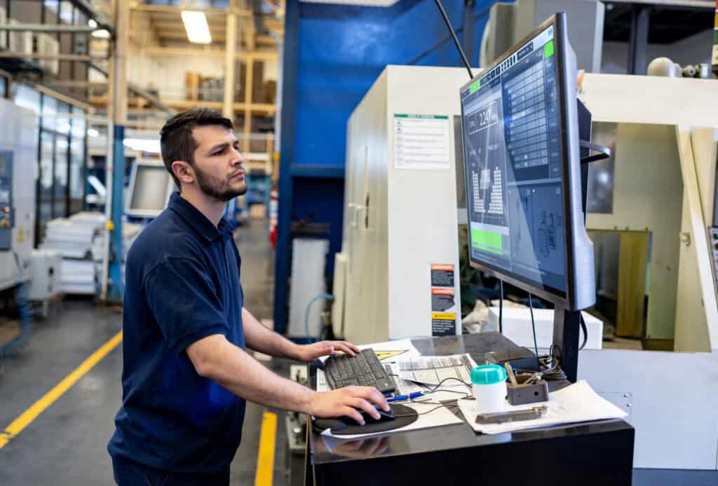 Man Operating A Cutting Machine At A Manufacturing Factory